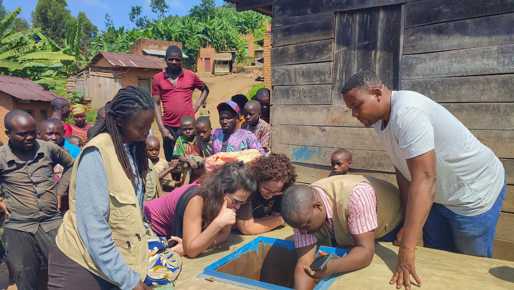 Emanuela di AMU e i partner locali in Burundi ispezionano una fonte d'acqua per il nuovo acquedotto.