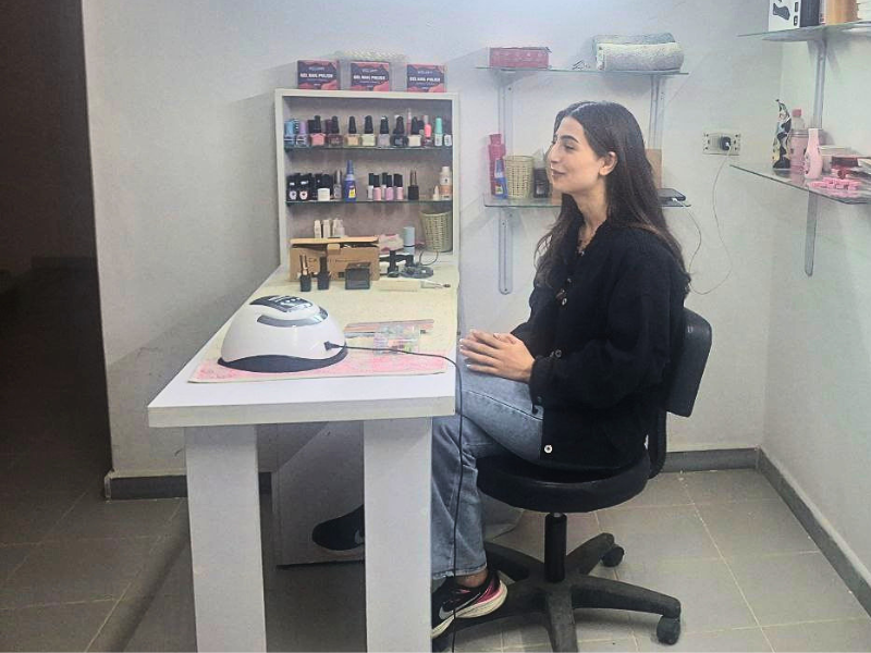L'onicotecnica Silva seduta alla sua postazione di lavoro professionale a Homs, fornita dal Progetto RestarT Siria.