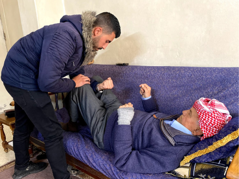 Aziz Hanna esegue esercizi di fisioterapia con un terapista dello Step Center per recuperare la mobilità delle gambe in Siria