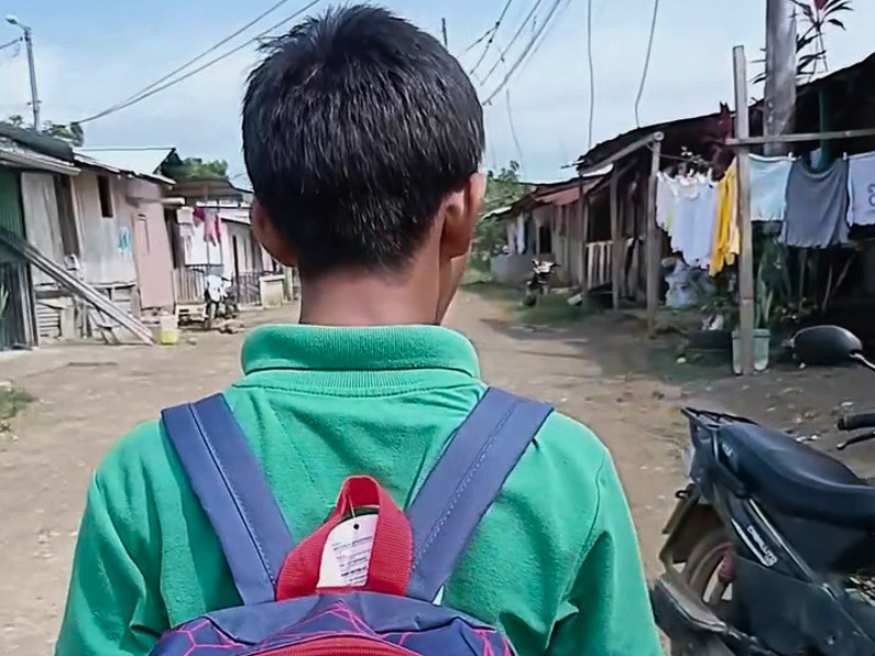 Un ragazzo cammina nella sua comunità con lo zaino ricevuto grazie al progetto di sostegno scolastico per i bambini in Ecuador.