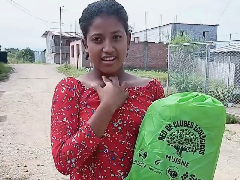 Una ragazza mostra il materiale ricevuto per il sostegno scolastico dei bambini in Ecuador nel progetto a Muisne.