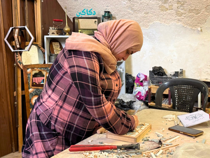 Artist Asmaa at work in her workshop in Aleppo, designing and creating a mosaic as part of a vocational training project for women in Syria.