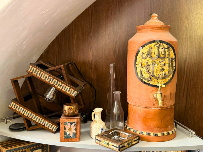 Wooden furnishings and designer lamps with natural stone mosaic inserts, made in Aleppo as part of a vocational training project for women in Syria.