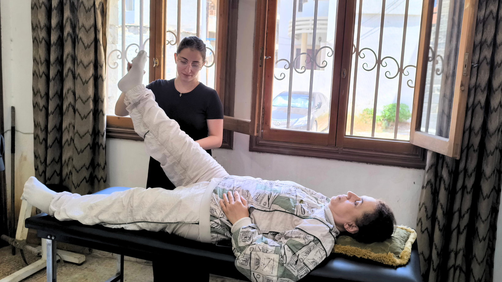 Una donna esegue esercizi di fisioterapia con l'aiuto di una terapista nel centro medico dei progetti umanitari in Siria.
