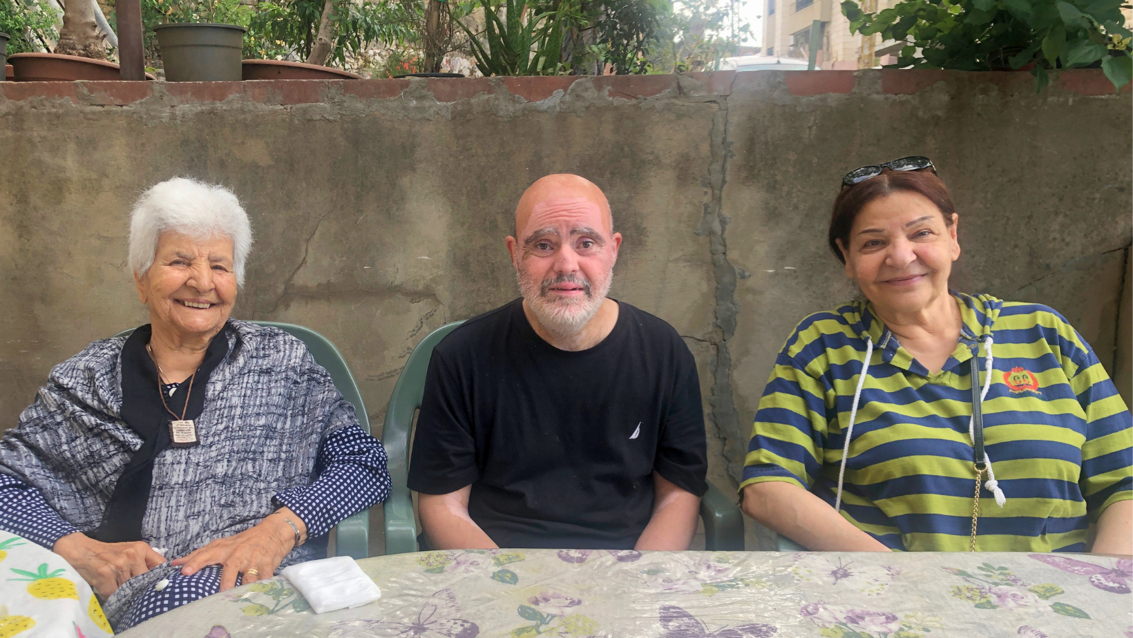 Una famiglia libanese sorridente nel salotto di casa, simbolo delle storie di solidarietà e reciprocità in Libano.