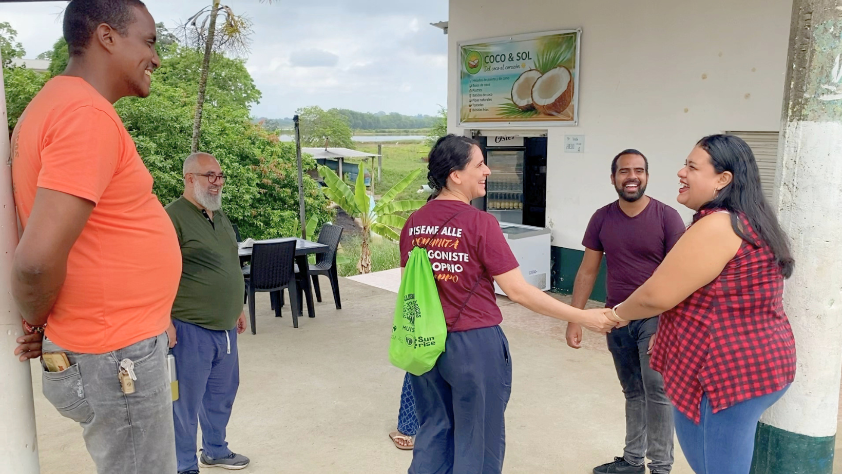 Lia e Tainã stringono la mano a imprenditori locali davanti al laboratorio COCO&SOL a Muisne, sostenuto dal Progetto Sunrise+ Ecuador.