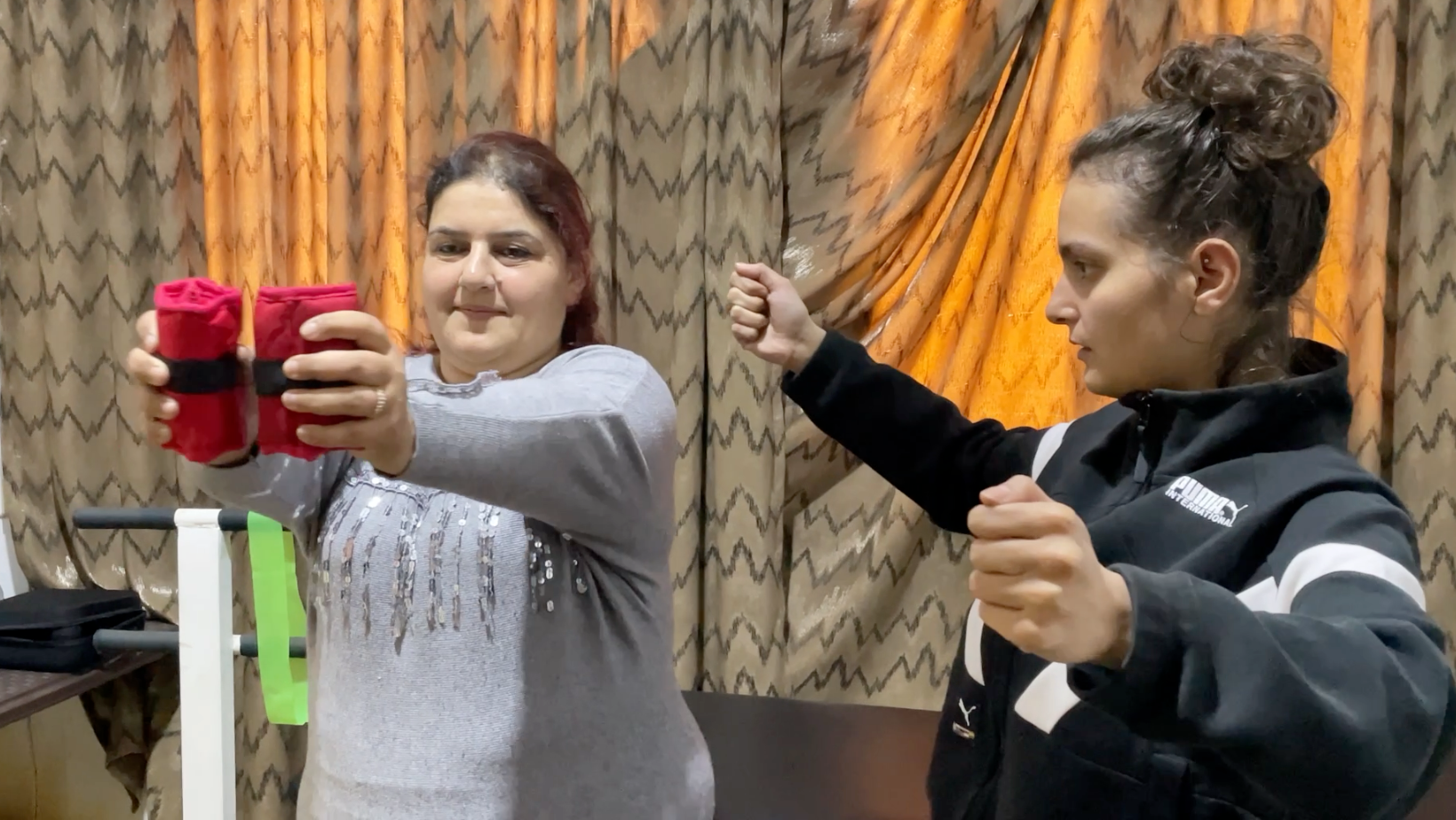 Maysaa esegue esercizi di fisioterapia con i pesi insieme alla terapista dello Step Center a Homs