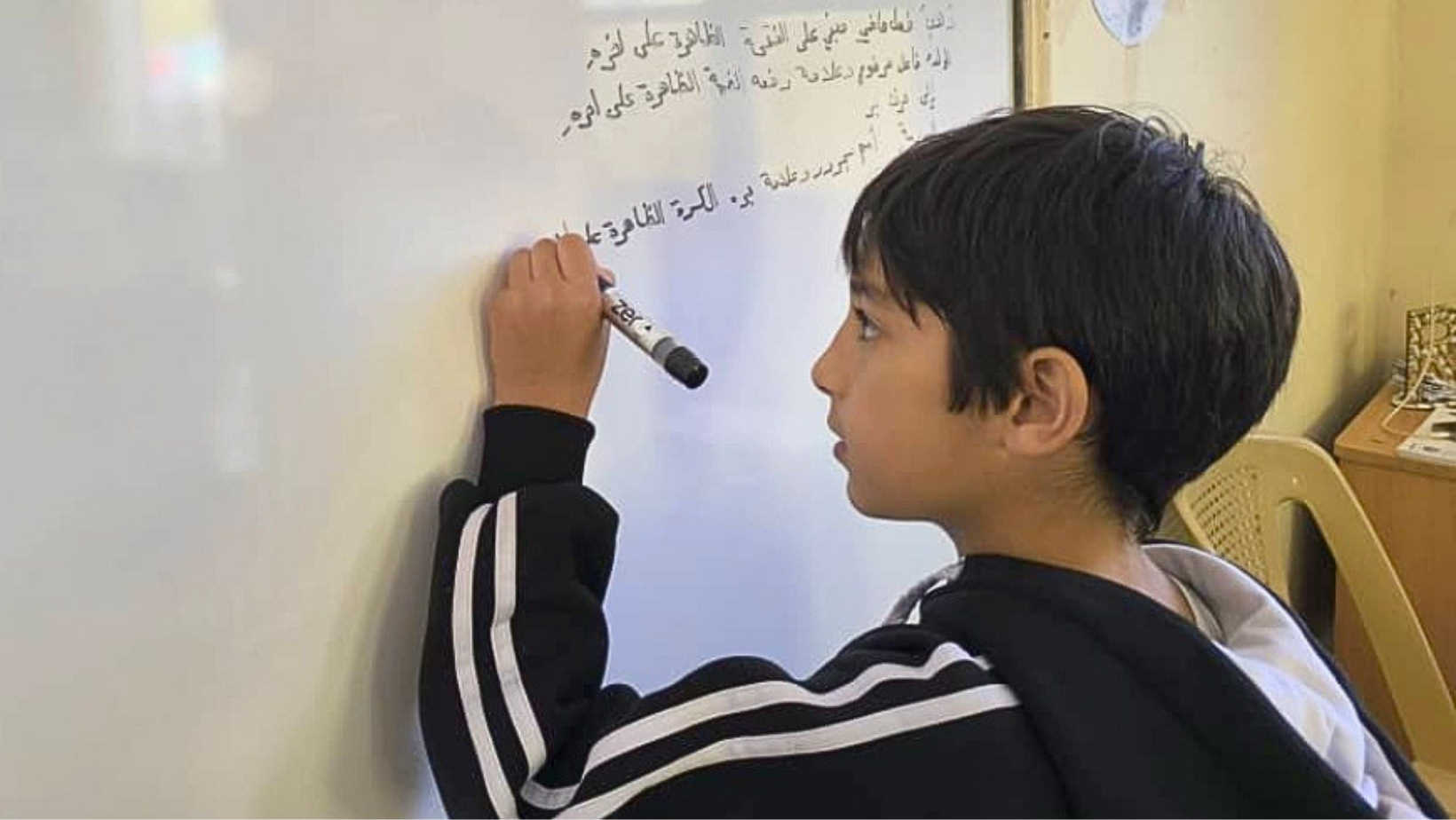 Il piccolo Bashir scrive alla lavagna: siamo in una delle aule del centro Little Dreams di Baniyas (Siria)